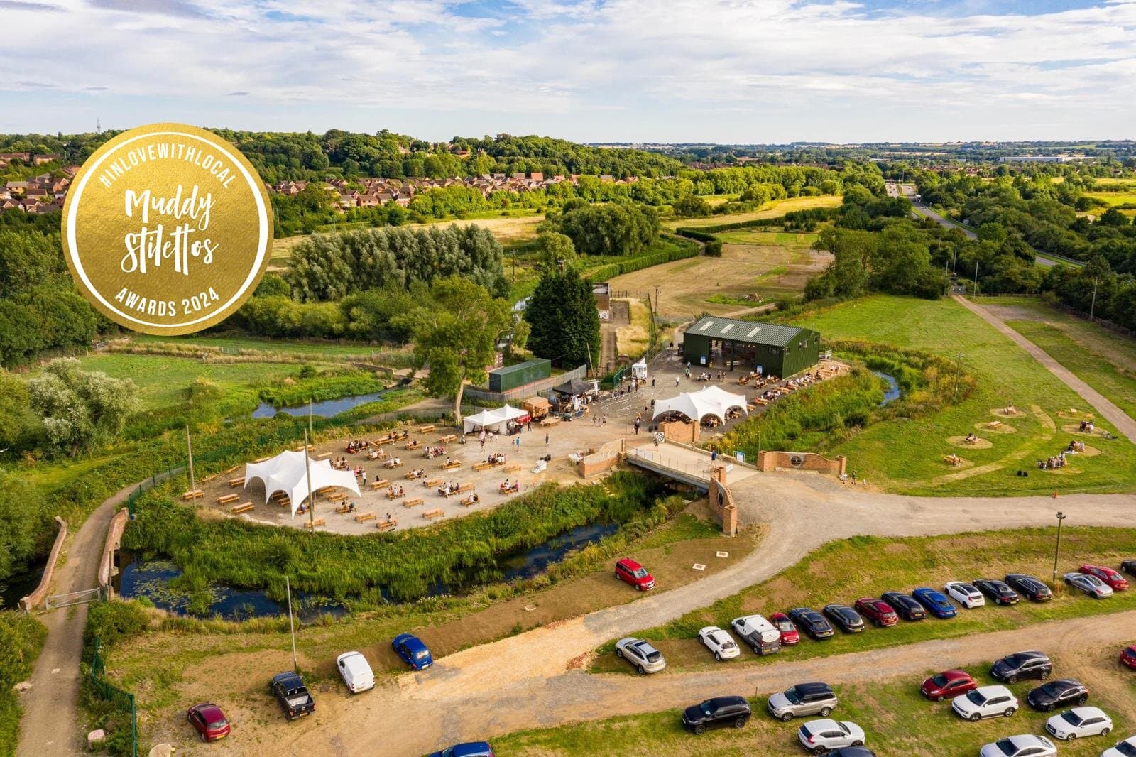 Aerial view of Duston Mill venue, countryside setting with barn, marquees, and river